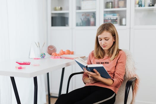 Woman Sitting on Chair While Reading a Book